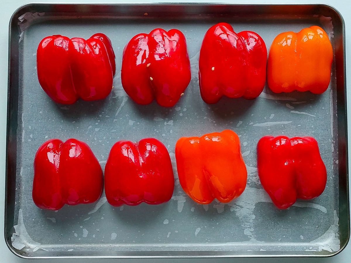 Bell pepper halves arranged on a sheet pan for roasting.