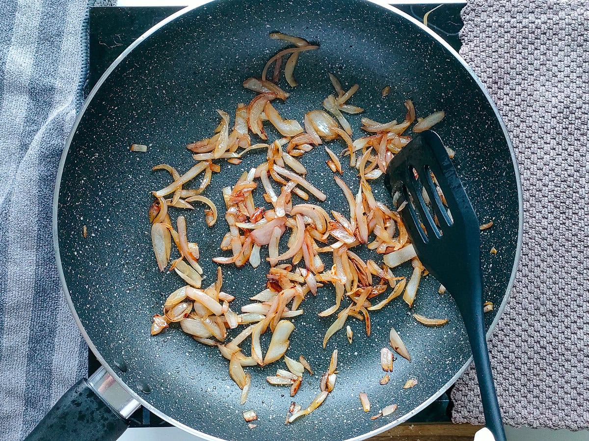 Wholesome Chipotle Chicken Sandwich with Easy Avocado Spread Sauteed onions in a pan.