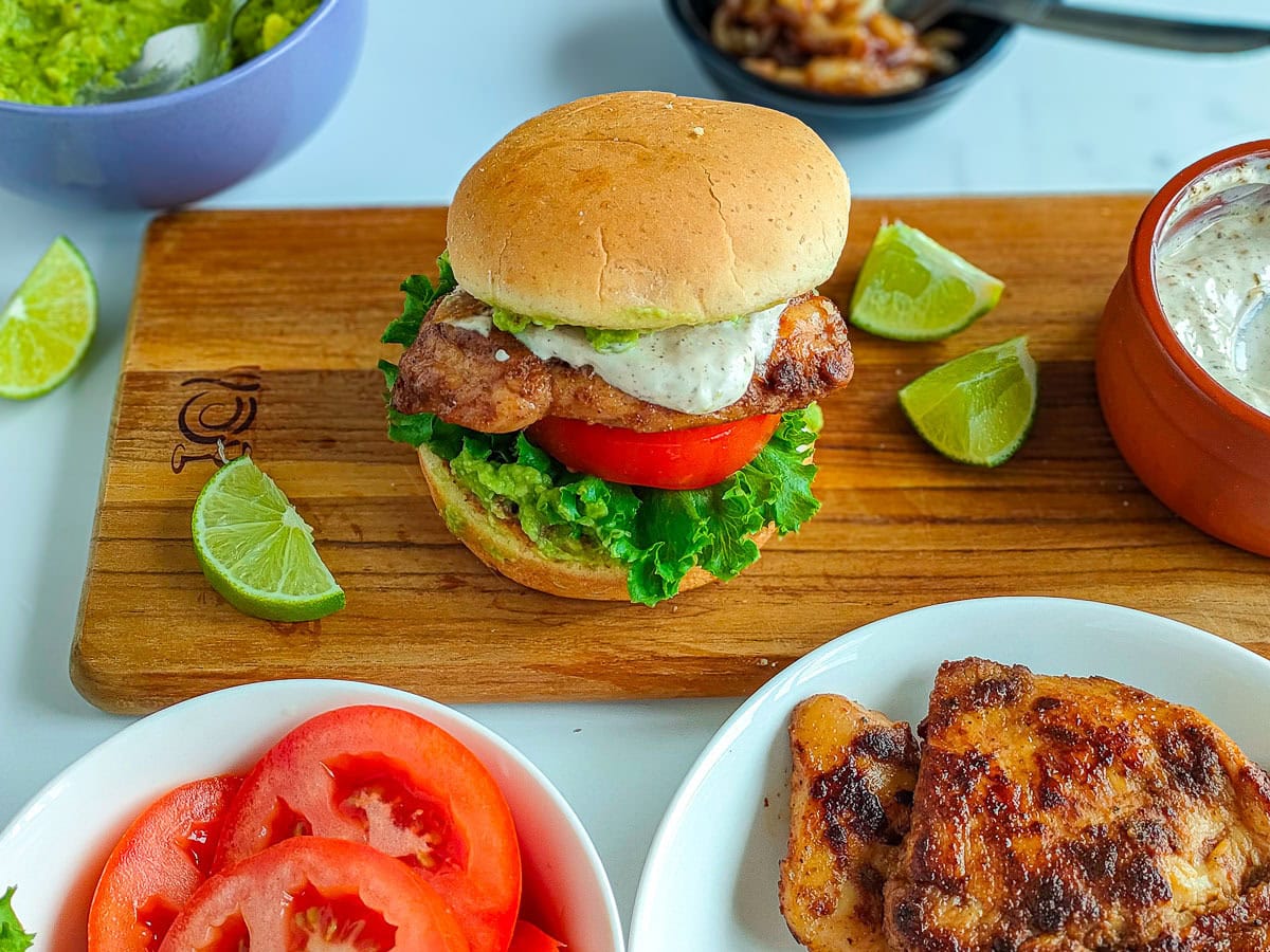 Wholesome Chipotle Chicken Sandwich with Easy Avocado Spread Homemade chipotle chicken sandwich on a serving board with yogurt sauce, avocado spread and pan fried chipotle chicken next to it.