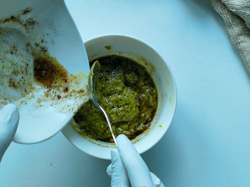 Oil and spice mixture being added to pesto.