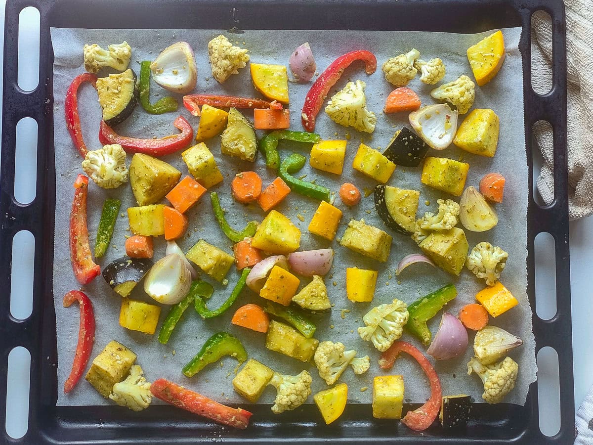 Easy Roasted Pesto Vegetables (Mediterranean style) Diced vegetables with pesto sauce on a sheet pan.
