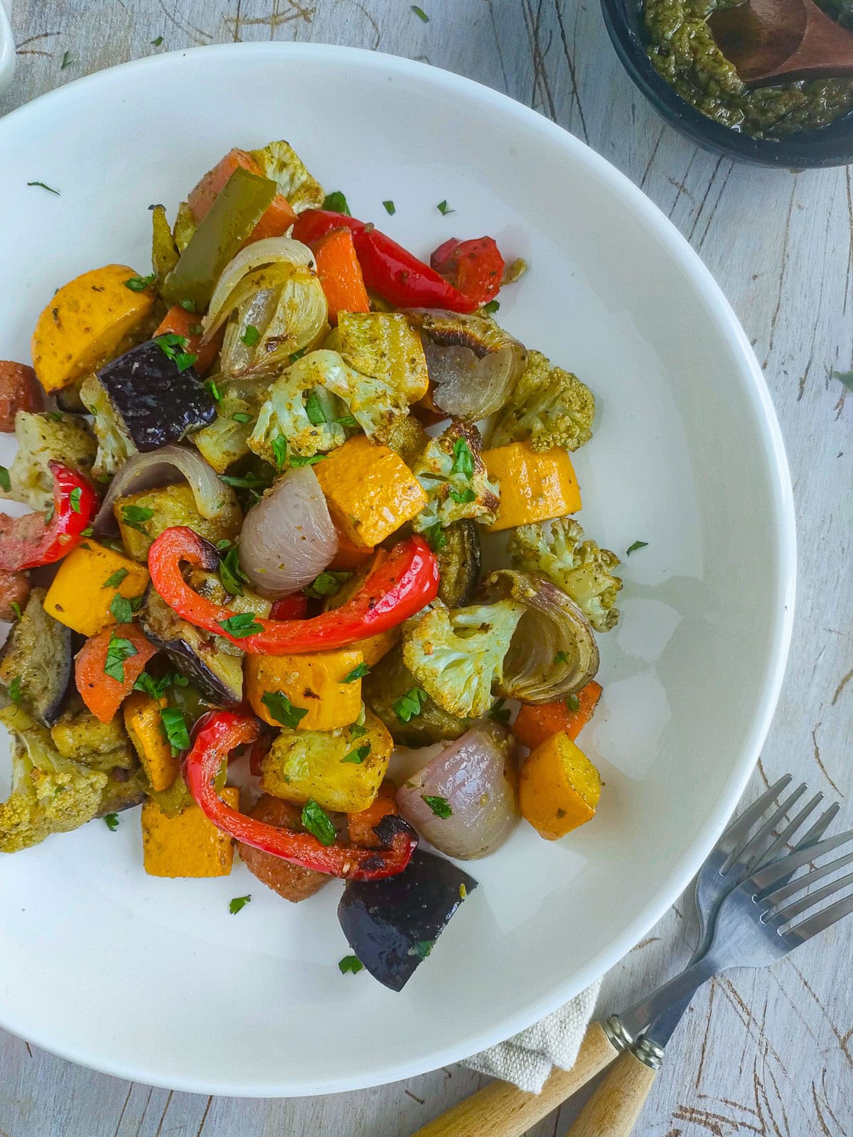 Easy Roasted Pesto Vegetables (Mediterranean style) Mediterranean roasted pesto vegetables on a white plate.