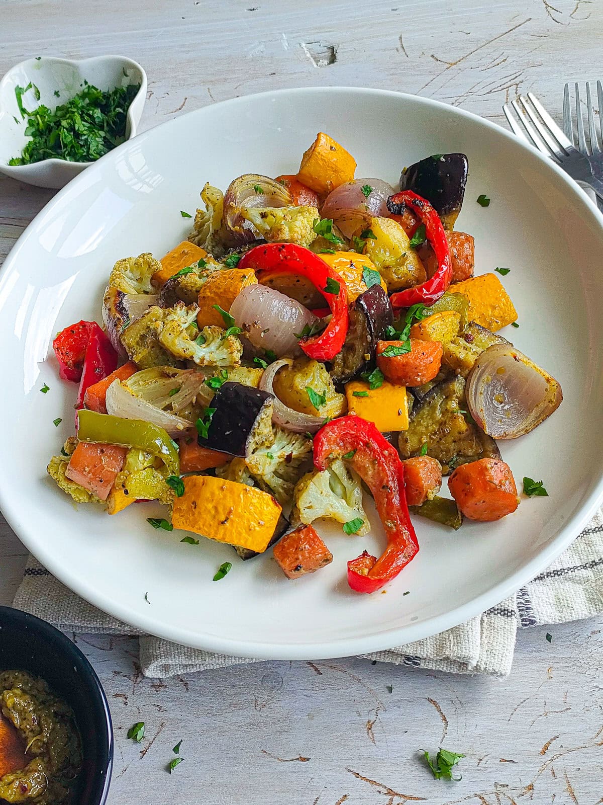 Easy Roasted Pesto Vegetables (Mediterranean style) Pesto roast vegetables on a white plate.