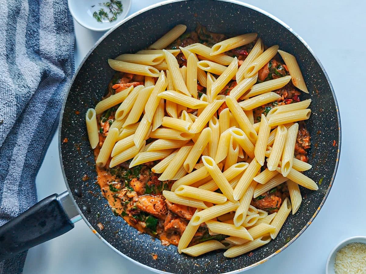 Cajun Pasta with Salmon (without cream) Pasta with creamy Cajun salmon sauce in a large pan.