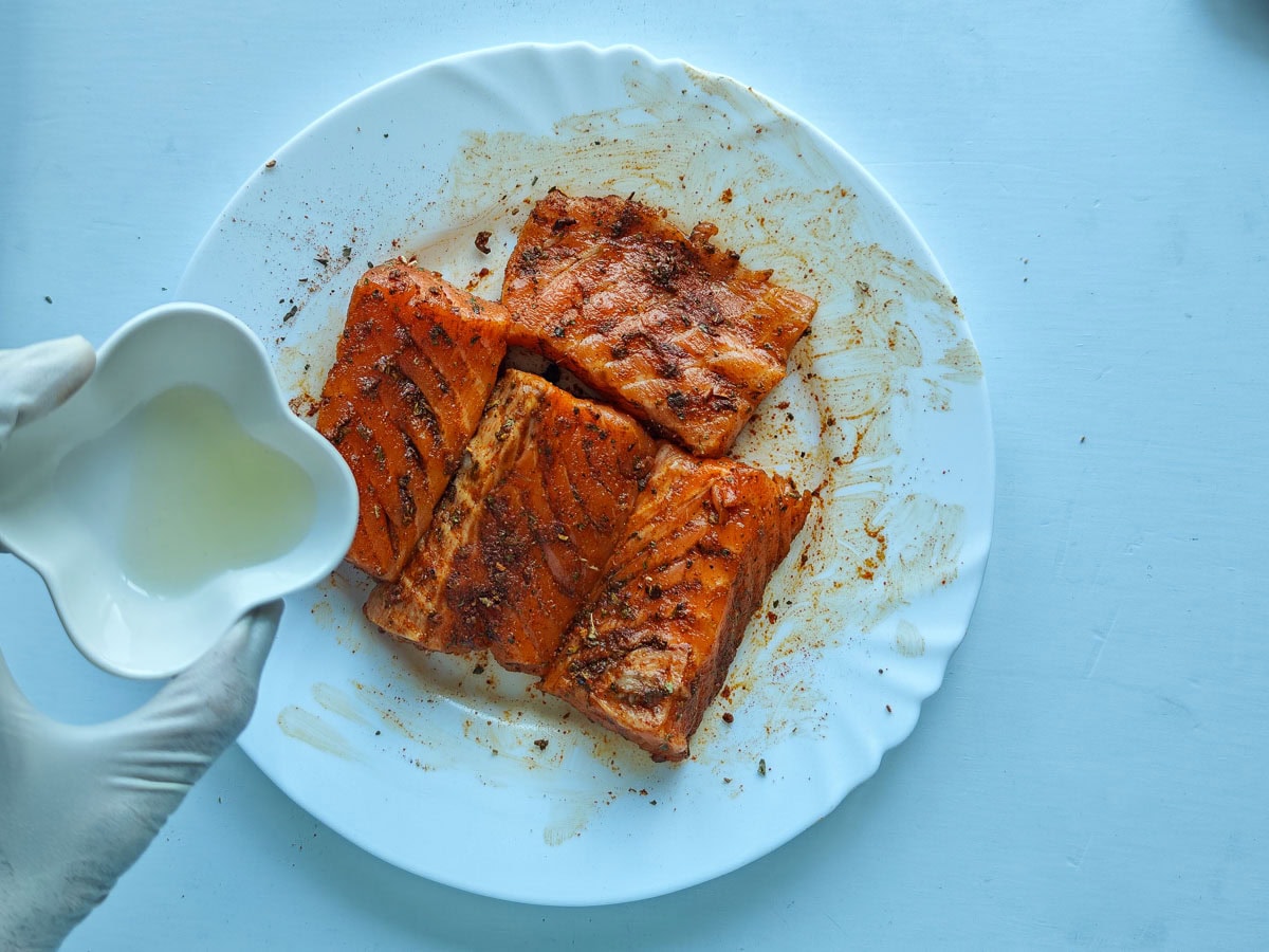 Cajun Pasta with Salmon (without cream) Salmon seasoned with Cajun spices and lemon juice on a white plate.