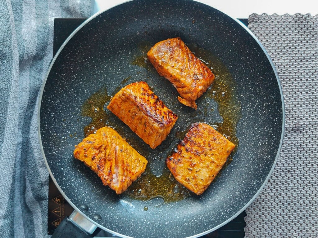 Cooked Cajun salmon in a pan.