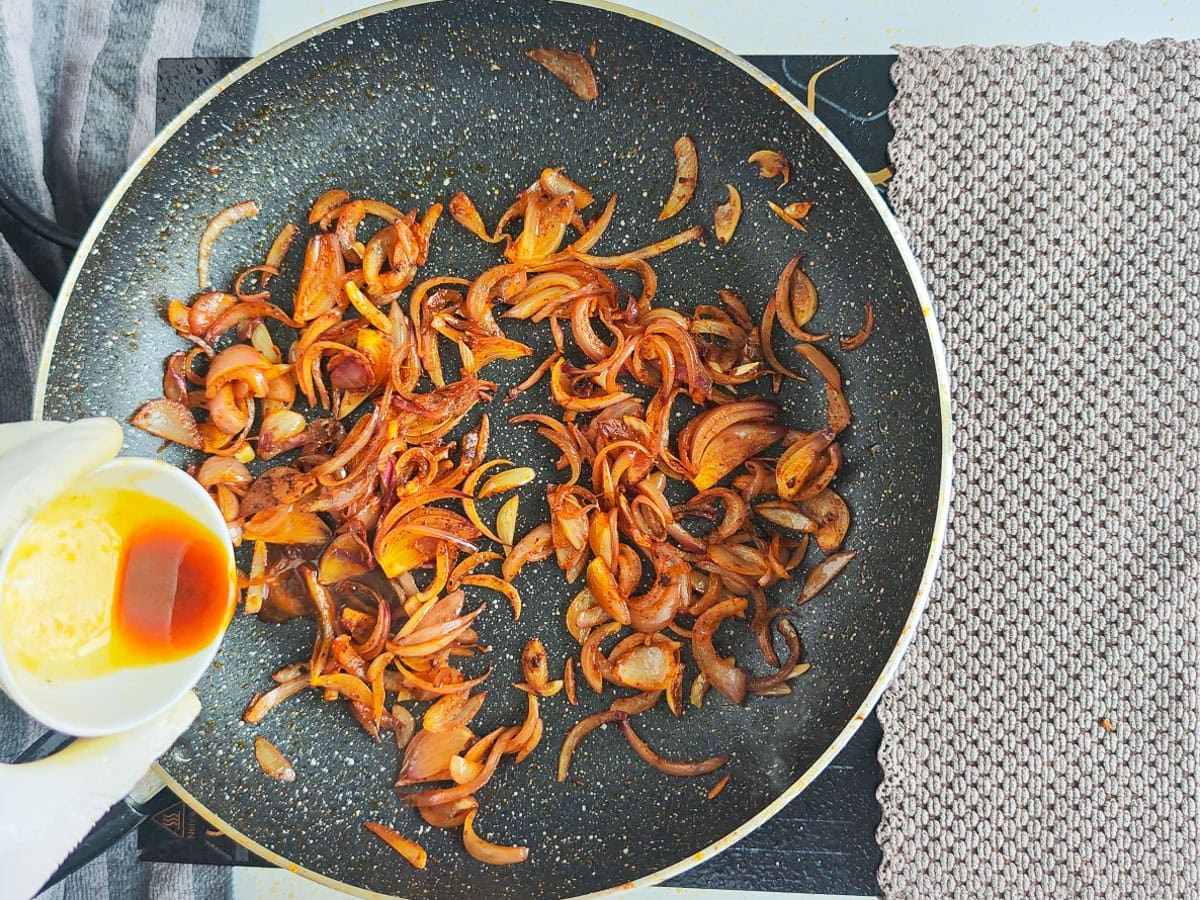 Mediterranean Chicken Shawarma Plate Pan juices from chicken being added to browned onions in a sauté pan.