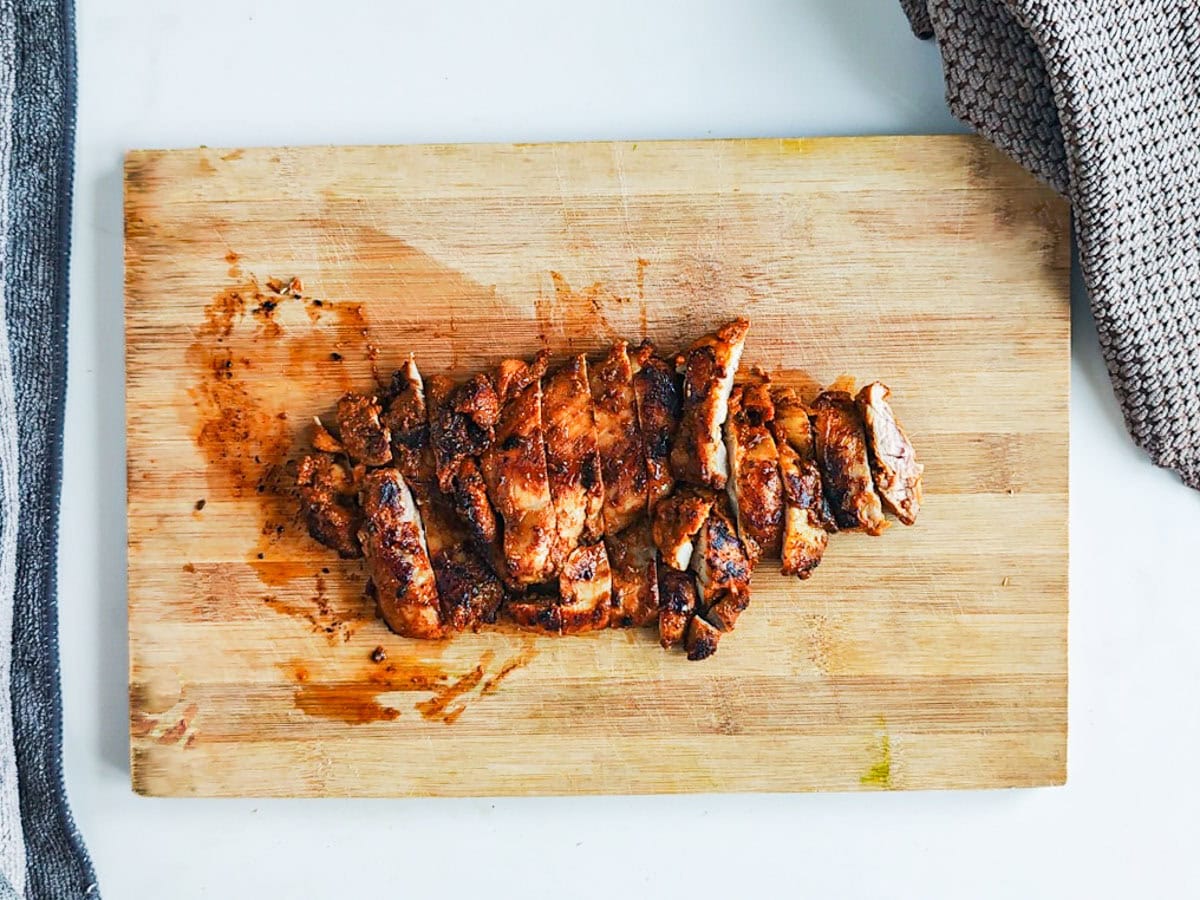 Mediterranean Chicken Shawarma Plate Slices of shawarma chicken on a chopping board.