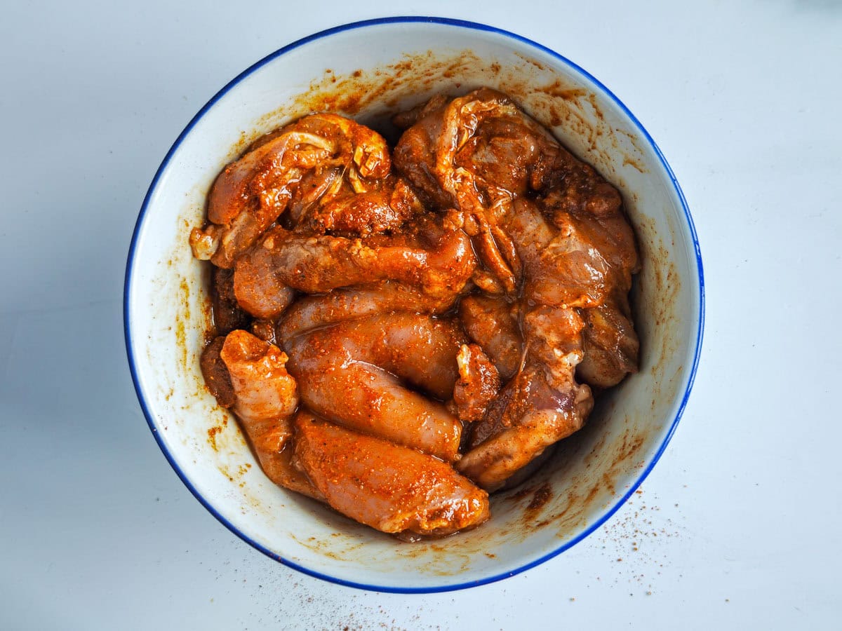 Mediterranean Chicken Shawarma Plate Chicken mixed with shawarma marinade in a bowl.