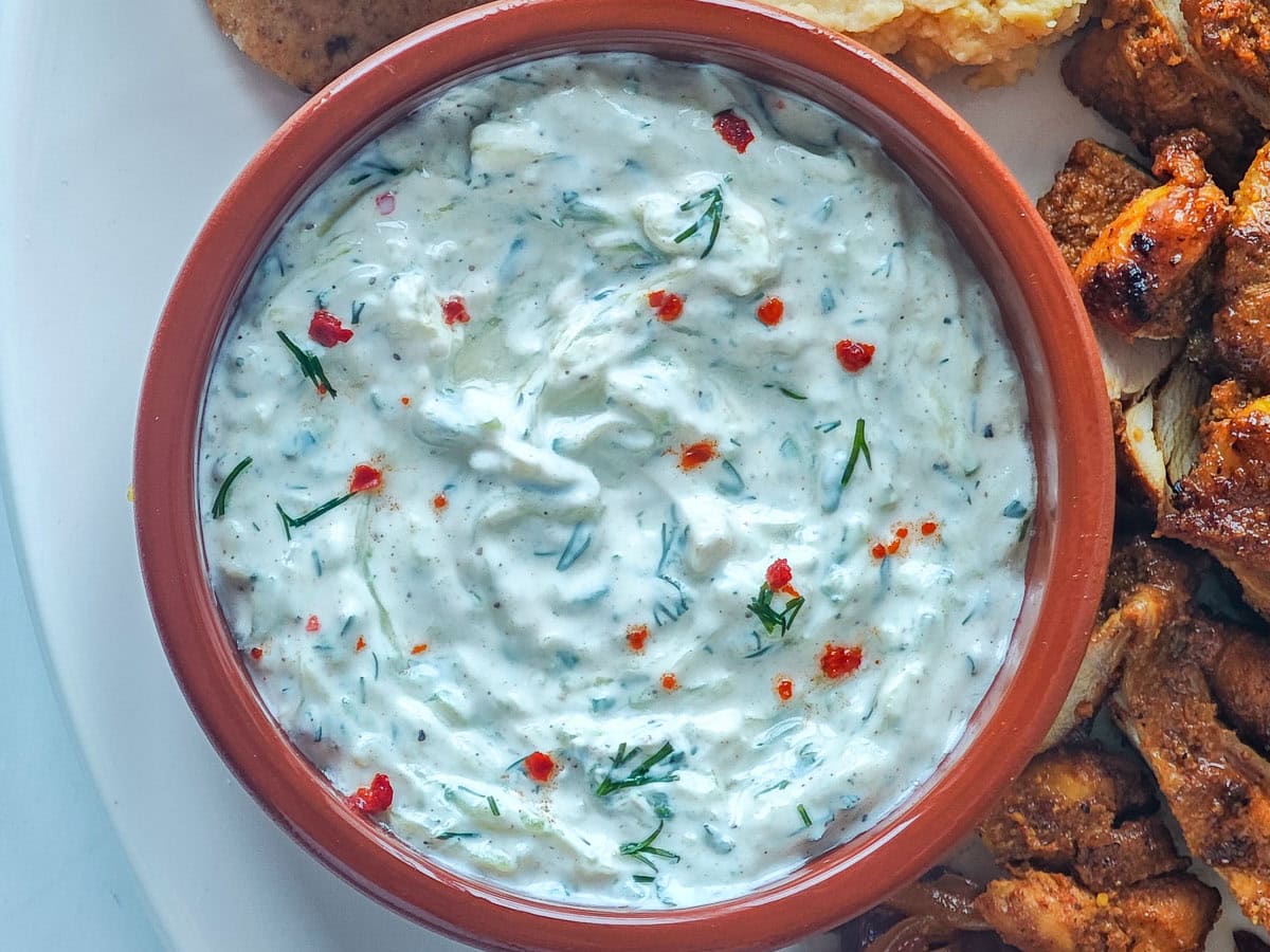 Creamy Cucumber Dill Tzatziki (Greek Yogurt Cucumber Dip) Cucumber Greek yogurt dip in a brown bowl.
