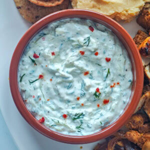 Creamy Cucumber Dill Tzatziki (Greek Yogurt Cucumber Dip) Cucumber dill tzatziki in a brown bowl.