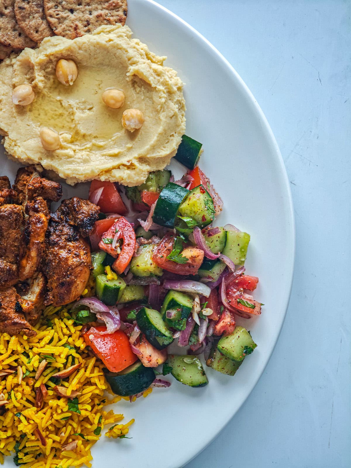 Quick Cucumber Tomato Mediterranean Salad (no dressing required) Mediterranean cucumber tomato salad as part of a shawarma plate with hummus, chicken and Mediterranean rice.