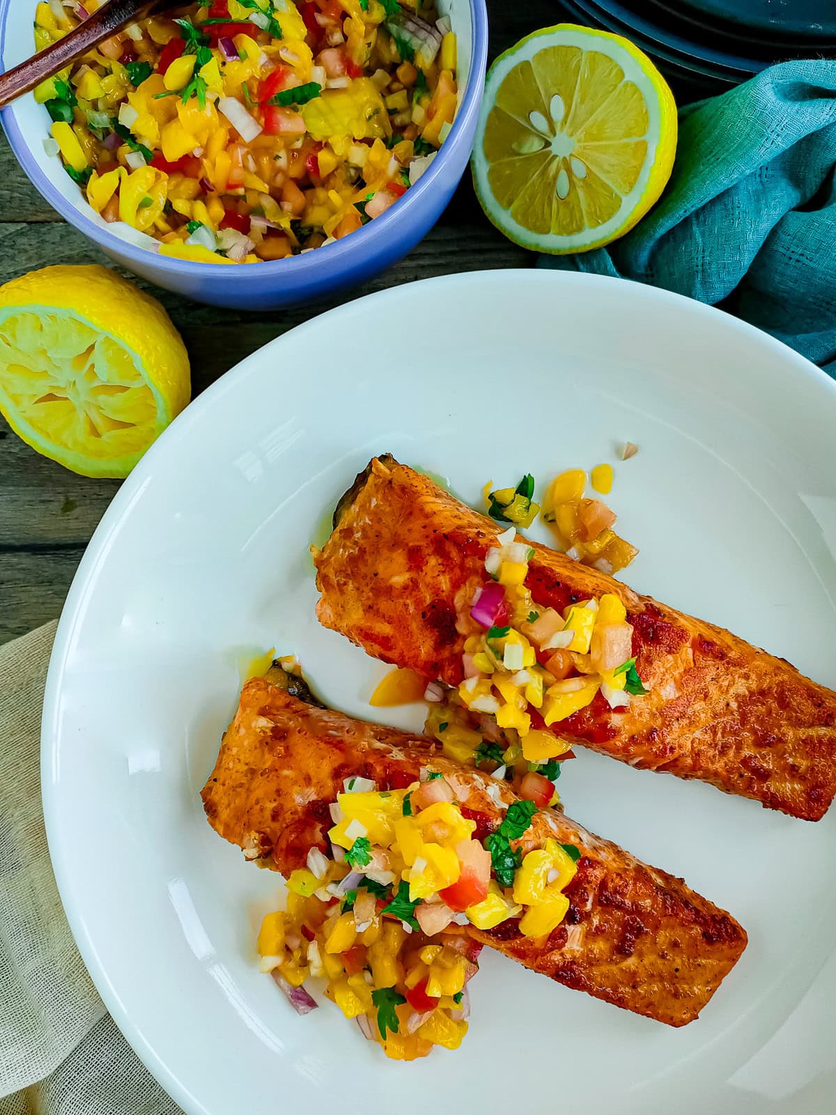 Mango Jalapeño Salsa with Tomatoes Jalapeno mango salsa with paprika salmon on a white plate.
