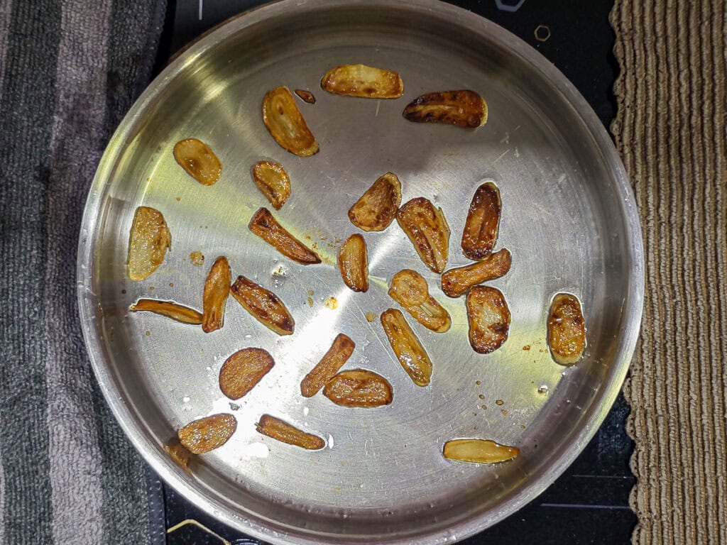 Garlic roasted with olive oil in a pan.