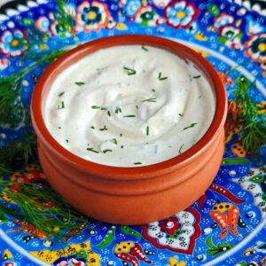 Easy Garlic Yogurt Sauce (with Roasted Garlic) Roasted garlic yogurt sauce with dill in a bowl.