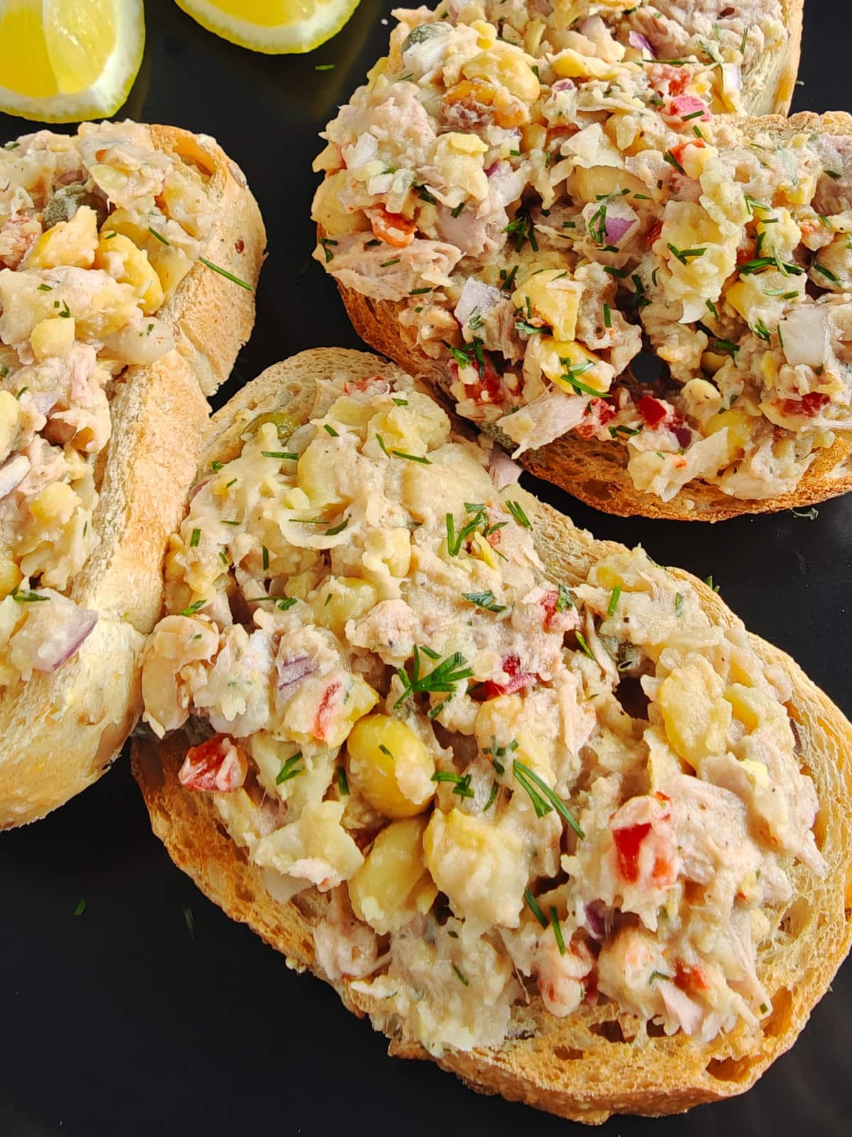 Mediterranean Chickpea Tuna Salad (No Mayo, High Protein) Chickpea tuna salad sandwich on a black plate.