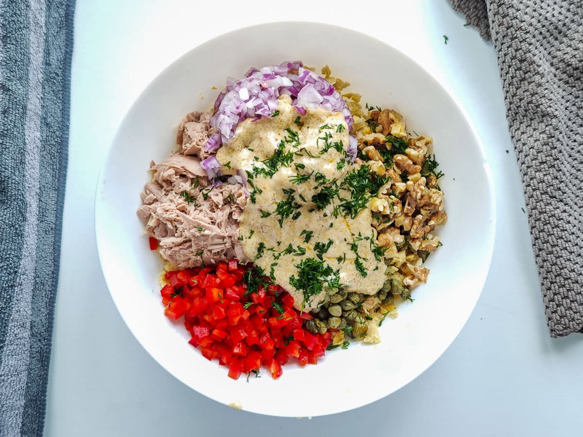 Mediterranean Chickpea Tuna Salad (No Mayo, High Protein) Flaked tuna, mashed chickpeas, bell peppers, onions and capers with yogurt dressing in a large white bowl.
