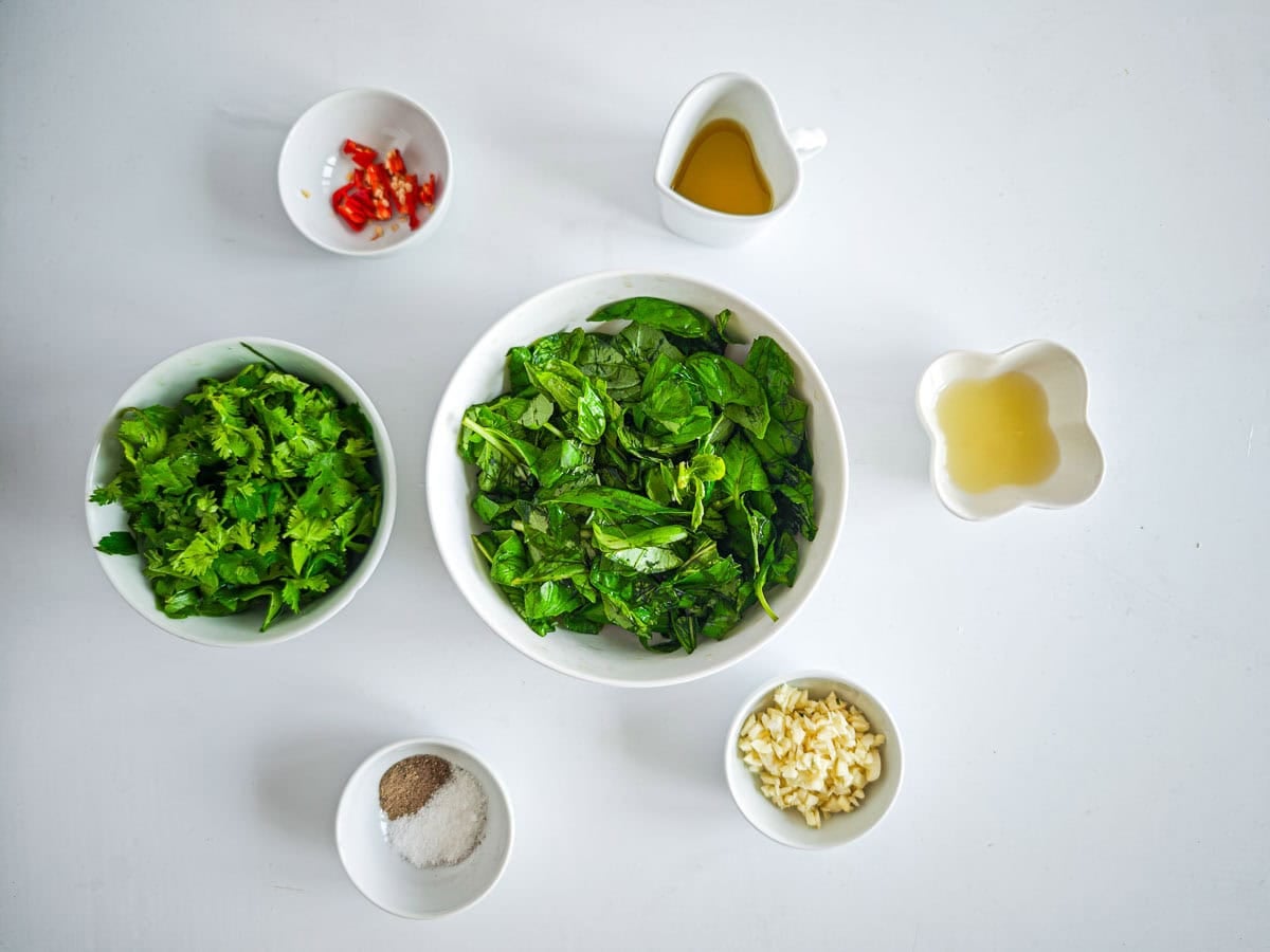 Low-calorie Basil Chimichurri (without excess oil) Prepared ingredients for chimichurri sauce with basil in separate bowls.