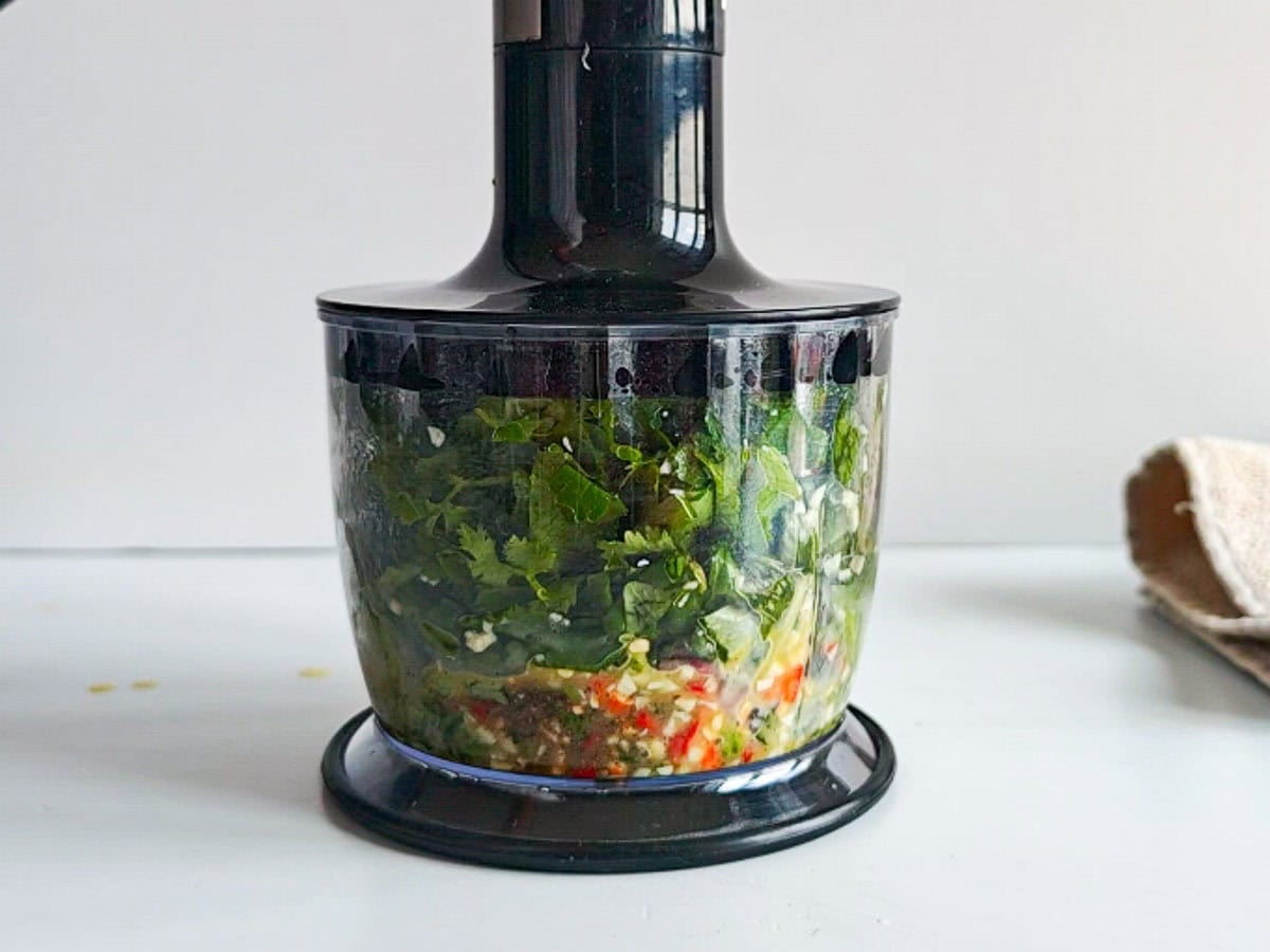 Low-calorie Basil Chimichurri (without excess oil) Basil and parsley with other ingredients in a blender.