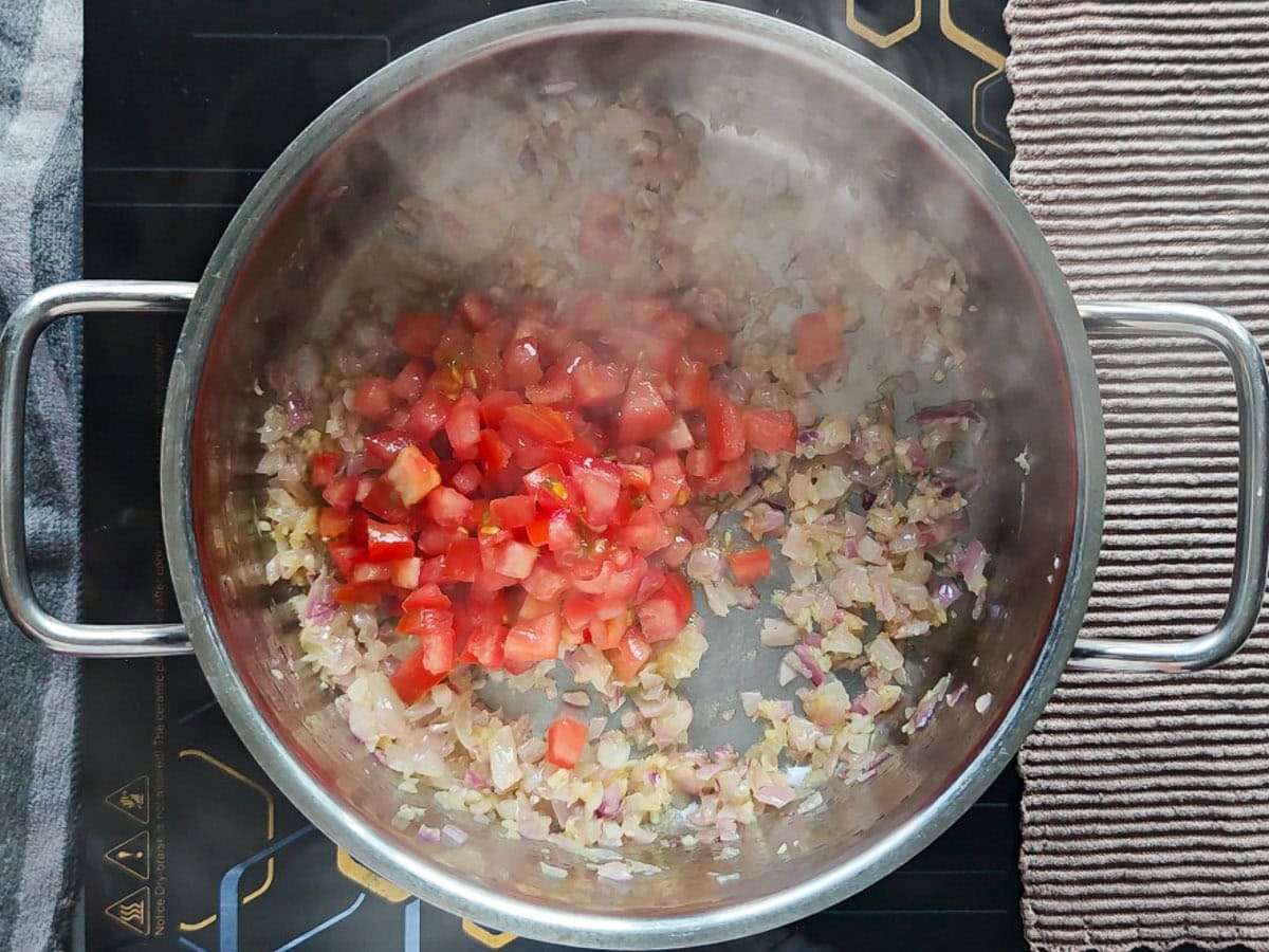 Easy Chimichurri Rice with Vegetables Tomatoes with sauteed onion and garlic in a pot.