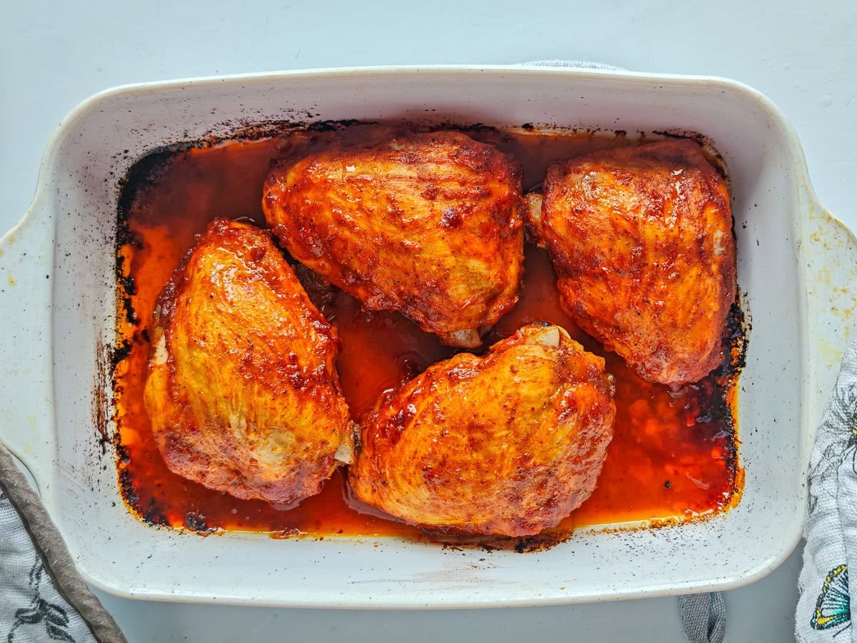 Easy Gochujang Chicken Thighs (Sticky & Oven-Baked) Baked gochujang chicken thighs in a baking dish.