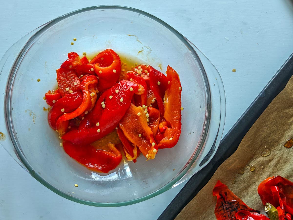 Easy Red Chimichurri Sauce with Roasted Peppers Roasted and peeled peppers in a glass bowl.