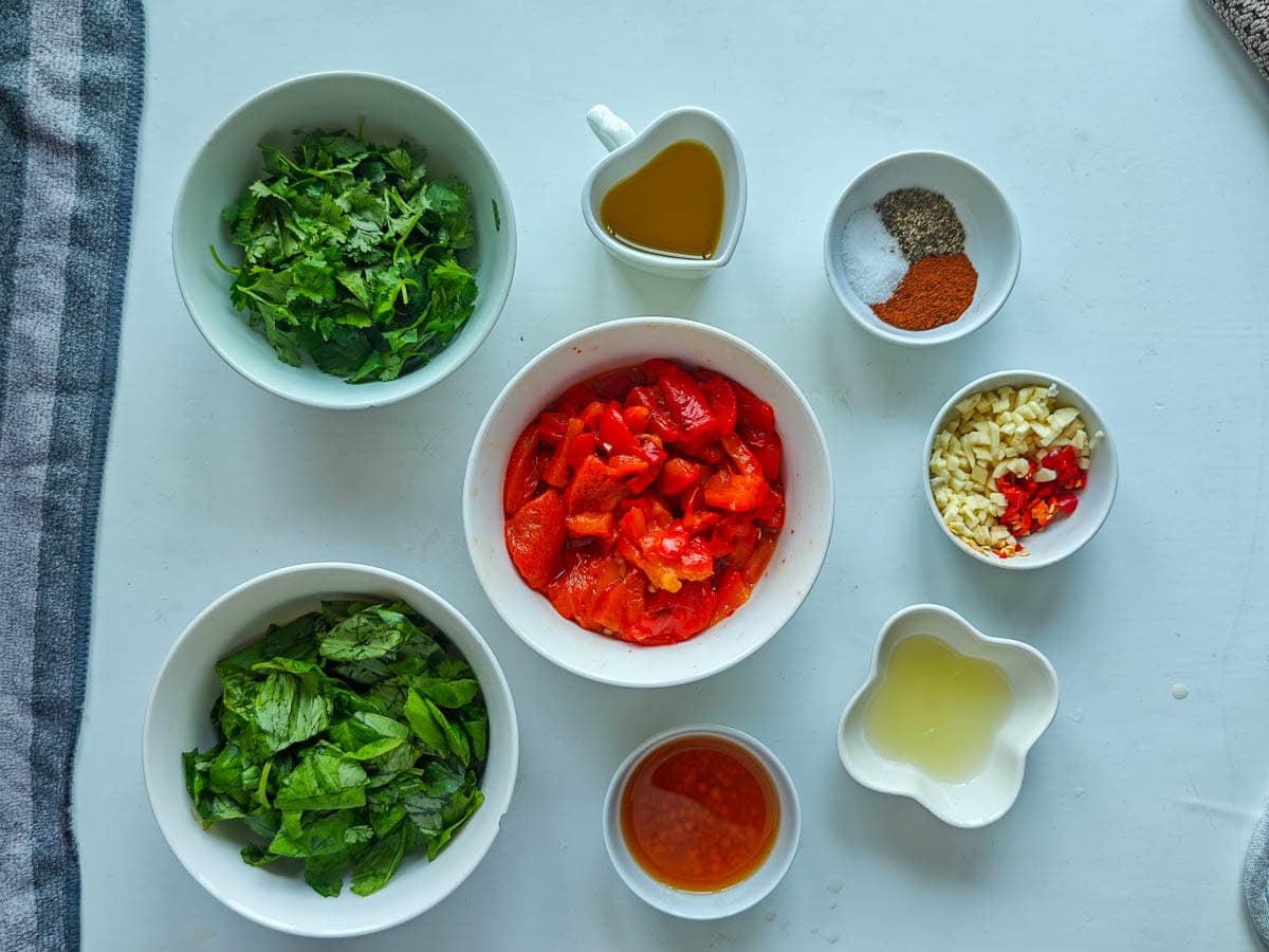 Easy Red Chimichurri Sauce with Roasted Peppers Prepared ingredients for red chimichurri in separate bowls.