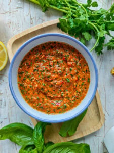 Easy Red Chimichurri Sauce with Roasted Peppers Red chimichurri with roasted peppers in a bowl.
